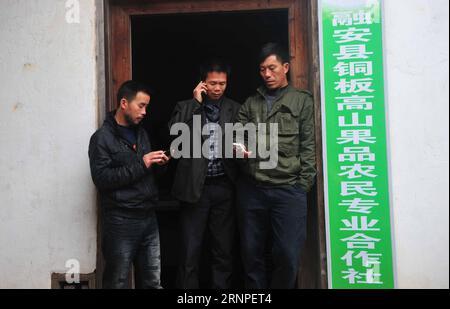 (170826) -- RONG AN, agosto 26, 2017 -- Long Gexiong (C), Long Feilian (L) e Long Feizhen sono visti fuori dall'ufficio di cooperativa nel villaggio di Tongban della contea di Rong An, nella regione autonoma di Guangxi Zhuang nella Cina meridionale, 21 febbraio 2014. Il villaggio di Tongban si trova in un'area montuosa del Guangxi. Il lavoratore migrante Long Gexiong di 50 anni ha scelto di rimanere nella città natale di Tongban dopo il Festival di Primavera del 2012. Lanciò un progetto per sviluppare la sua città natale e istituì una cooperativa con i suoi cugini. Hanno piantato prugne e uva e hanno fatto affari turistici con capitale iniziale che hanno guadagnato come Foto Stock