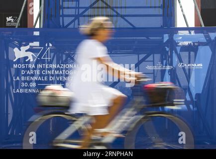 (170829) -- VENEZIA, 29 agosto 2017 -- Una donna passa davanti alla pubblicità della 74a Mostra Internazionale d'Arte cinematografica di Venezia, Italia, il 29 agosto 2017. Il 74° Festival del Cinema di Venezia avrà inizio a Lido di Venezia il 30 agosto e si svolgerà fino al 9 settembre. ) (zw) ITALY-VENICE-FILM FESTIVAL JinxYu PUBLICATIONxNOTxINxCHN Venice Aug 29 2017 a Woman Rides Past the Advertisement of the 74th Venice International Film Festival in Venice Italy IL 29 2017 agosto la 74th Venice Film Festival prenderà il via al Lido di Venezia IL 30 agosto e durerà fino al 9 settembre ZW Festival del Cinema di Venezia JinxYu PUBLICATIONxNOTx Foto Stock