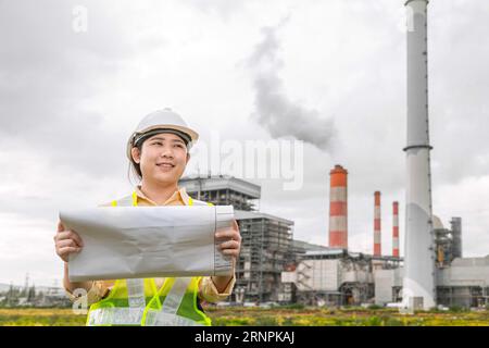 Ingegnere donna lavoratrice con progettista edile di planimetrie responsabile di progetto che cerca di lavorare sul campo Foto Stock