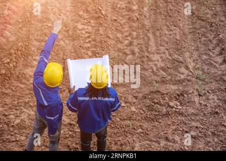 progetta un lavoro di squadra di surveryor terrestri per ispezionare il sito di contruzione per il progetto di costruzione con planimetria Foto Stock