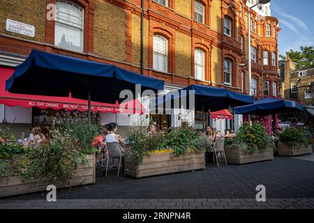 Londra, Regno Unito: Exhibition Road a South Kensington, Londra. La gente siede in un ristorante vicino alla stazione della metropolitana di South Kensington. Foto Stock