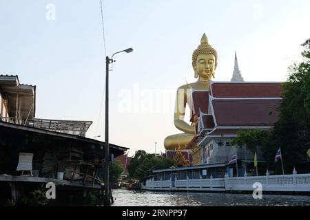 Enorme statua dorata del Buddha a Wat Paknam Pasi Charoen nella parte occidentale di Bangkok Foto Stock