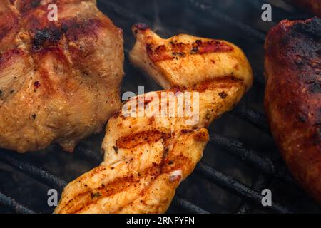 Primo piano sui dettagli della bistecca di pollo fatta in casa sulla griglia barbecue. Barbecue, grigliate e concetto di cibo. Foto Stock