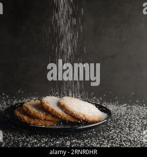 Biscotti di farina d'avena cosparsi di zucchero bianco. Sfondo grigio scuro. Menu caffetteria. Foto Stock