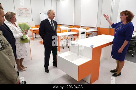 Villaggio di Turginovo, Russia. 2 settembre 2023. Il presidente russo Vladimir Putin, centro accompagnato dal preside della scuola Olga Karaseva, sinistra, ascolta un insegnante spiegare il nuovo laboratorio di scienze durante un tour di una nuova scuola secondaria completa, il 2 settembre 2023 a Turginovo, regione di Tver, Russia. Crediti: Mikhail Klimentyev/Cremlino Pool/Alamy Live News Foto Stock