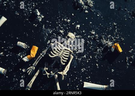 Lo scheletro umano giace con una sigaretta in una stanza fumosa. Il concetto di antifumo. Fumare uccide. Foto Stock