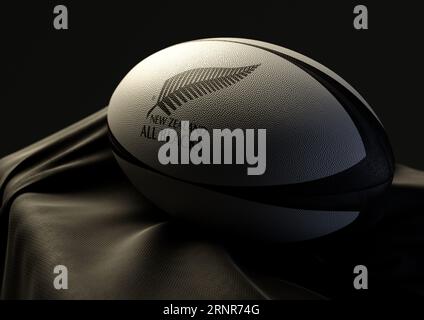 2 settembre 2023 - Bristol, Regno Unito: Una rappresentazione in 3D di una palla da rugby impressa con il logo del rugby New Zealand All Blacks appoggiato su un bagliore drappeggiato Foto Stock