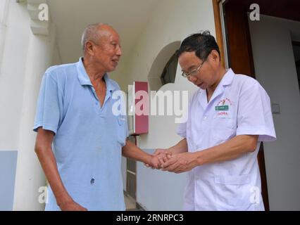 (171012) -- PECHINO, 12 ottobre 2017 -- dermatologo Xu Genbao (R) dà un controllo medico per un paziente presso il centro di riabilitazione della provincia di Jiangxi dermatosi ospedale speciale nella città suburbana di Nanchang, capitale della provincia di Jiangxi della Cina orientale, 29 settembre 2017. Xu ha lavorato in questo centro isolato per la lebbra da 28 anni. È stato eletto come delegato per partecipare al 19° Congresso Nazionale del Partito Comunista Cinese (CPC) a Pechino dal 18 ottobre. In circa un anno, un totale di 2.287 delegati sono stati eletti per partecipare al congresso nazionale quinquennale. Secondo i requiremen Foto Stock
