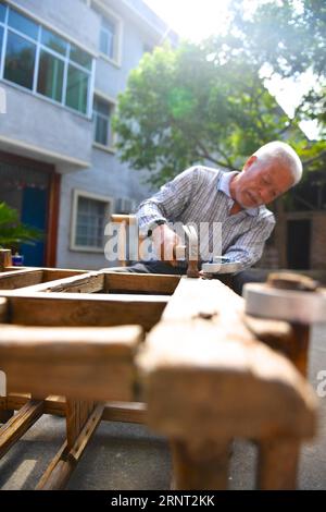 (171027) -- NANCHANG, 27 ottobre 2017 -- Zhong Ruijin fissa una sedia a rotelle speciale per Zhong Jiagu nel villaggio di Liantang della contea di Huichang, provincia orientale dello Jiangxi della Cina, 26 ottobre 2017. Zhong Jiagu fu abbandonato dai suoi genitori impoveriti 30 anni fa, quando nacque con rachitismo congenito incurabile. Fortunatamente per il neonato, è stato adottato dal villaggio Zhong Ruijin come nipote di Zhong. L'uomo dal cuore gentile si è preso cura di suo nipote negli ultimi 30 anni. Si tengono a vicenda, e non si pentono mai.) (wf) CHINA-JIANGXI-ADOPTION-DAILY LIFE (CN) HuxChenhuan PUBLICATIONxNOT Foto Stock