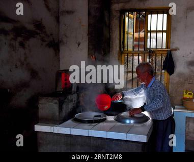 (171027) -- NANCHANG, 27 ottobre 2017 -- Zhong Ruijin pranza a casa nel villaggio di Liantang della contea di Huichang, provincia di Jiangxi della Cina orientale, 26 ottobre 2017. Zhong Jiagu fu abbandonato dai suoi genitori impoveriti 30 anni fa, quando nacque con rachitismo congenito incurabile. Fortunatamente per il neonato, è stato adottato dal villaggio Zhong Ruijin come nipote di Zhong. L'uomo dal cuore gentile si è preso cura di suo nipote negli ultimi 30 anni. Si tengono a vicenda, e non si pentono mai.) (wf) CHINA-JIANGXI-ADOPTION-DAILY LIFE (CN) HuxChenhuan PUBLICATIONxNOTxINxCHN Foto Stock