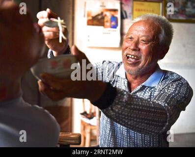 (171027) -- NANCHANG, 27 ottobre 2017 -- Zhong Ruijin (R) alimenta Zhong Jiagu nel villaggio di Liantang della contea di Huichang, provincia di Jiangxi della Cina orientale, 26 ottobre 2017. Zhong Jiagu fu abbandonato dai suoi genitori impoveriti 30 anni fa, quando nacque con rachitismo congenito incurabile. Fortunatamente per il neonato, è stato adottato dal villaggio Zhong Ruijin come nipote di Zhong. L'uomo dal cuore gentile si è preso cura di suo nipote negli ultimi 30 anni. Si tengono a vicenda, e non si pentono mai.) (wf) CHINA-JIANGXI-ADOPTION-DAILY LIFE (CN) HuxChenhuan PUBLICATIONxNOTxINxCHN Foto Stock