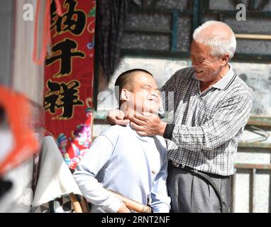 (171027) -- NANCHANG, 27 ottobre 2017 -- Zhong Ruijin (R) si prende cura di Zhong Jiagu nel villaggio di Liantang della contea di Huichang, provincia di Jiangxi della Cina orientale, 26 ottobre 2017. Zhong Jiagu fu abbandonato dai suoi genitori impoveriti 30 anni fa, quando nacque con rachitismo congenito incurabile. Fortunatamente per il neonato, è stato adottato dal villaggio Zhong Ruijin come nipote di Zhong. L'uomo dal cuore gentile si è preso cura di suo nipote negli ultimi 30 anni. Si tengono a vicenda, e non si pentono mai.) (wf) CHINA-JIANGXI-ADOPTION-DAILY LIFE (CN) HuxChenhuan PUBLICATIONxNOTxINxCHN Foto Stock