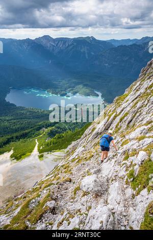 Via ferrata sul Riffelscharte, escursionista in montagna, vista del lago Eibsee e della Terra di Werdenfelser, dei Monti Wetterstein, Garmisch-Patenkirchen, B. Foto Stock
