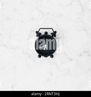 Sveglia nera con vista rialzata sfondo bianco con texture Foto Stock