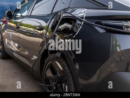 Palma di Maiorca, Spagna; 10 agosto 2023: Auto elettrica Peugeot nera che ricarica la batteria in un punto di ricarica elettrica. Palma de Mallorca, Spagna Foto Stock