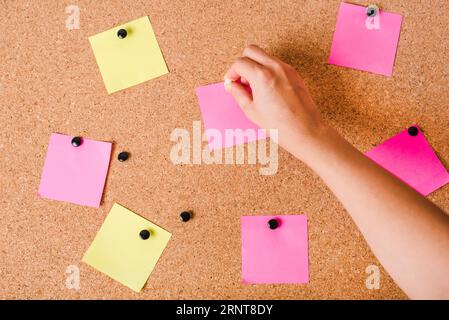 Avvicinare la mano della persona mettendo un pannello bianco per appunti con il perno a pressione Foto Stock