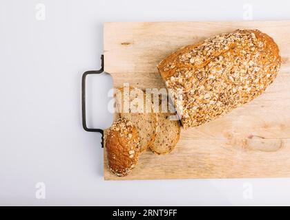 Vista dall'alto tagliere di pane integrale a fette con sfondo bianco Foto Stock