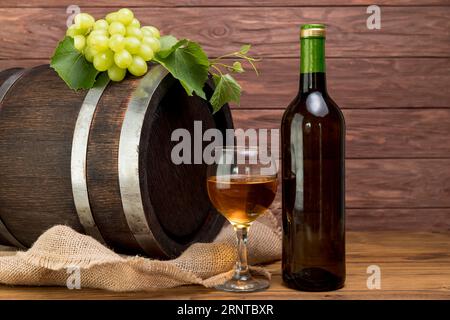 Botte di legno con bottiglia di vino in vetro Foto Stock