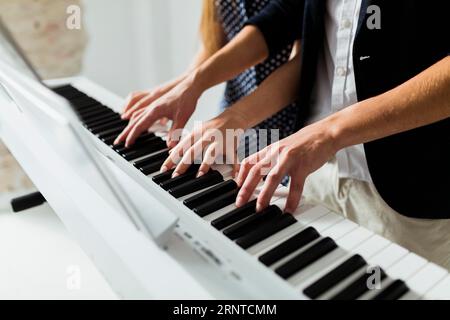 Primo piano con la mano che suona la tastiera del pianoforte Foto Stock