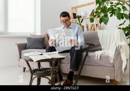 Uomo a pieno titolo che legge un giornale Foto Stock