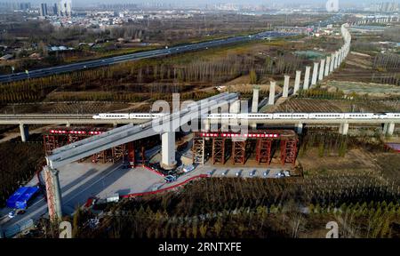 (171122) -- ZHENGZHOU, 22 novembre 2017 -- Un treno attraversa sotto un ponte a telaio rigido a forma di T in costruzione della ferrovia Zhengzhou-Wanzhou nel sobborgo di Zhengzhou, nella provincia di Henan nella Cina centrale, 22 novembre 2017. Il ponte a telaio rigido a forma di T sulla ferrovia ad alta velocità Pechino-Guangzhou ha completato una costruzione a rotazione mercoledì. ) (MCG) CHINA-ZHENGZHOU-WANZHOU RAILWAY-T-STRAIGHT FRAME BRIDGE (CN) ZHUXXIANG PUBLICATIONXNOTXINXCHN Foto Stock