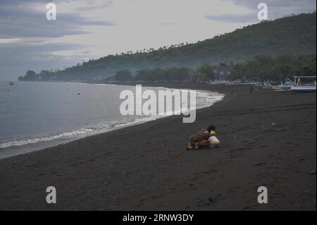 (171202) -- BALI, 2 dicembre 2017 -- le persone locali giocano sulla spiaggia di Amed a Karangasem, Bali, Indonesia, 2 dicembre. 2017. Gli impatti derivanti dalle crescenti attività vulcaniche del Monte Agung, nell'isola indonesiana di Bali, hanno colpito direttamente coloro che si guadagnano da vivere con attività turistiche ad Amed, un'area costiera orientale di Bali ben nota per le sue bellissime spiagge, il surf e i punti di immersione. Zulkarnai) (gj) INDONESIA-BALI-MONTE AGUNG-IL TURISMO IMPATTI *Zulkarnain* PUBLICATIONxNOTxINxCHN Foto Stock