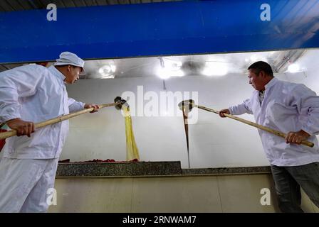 (171211) -- fu AN, 11 dicembre 2017 -- i lavoratori bollono il succo di canna da zucchero in un laboratorio di zucchero di canna nel villaggio di Hongkou di Xitan Township in fu An, provincia del Fujian della Cina sudorientale, 9 dicembre 2017. La gente qui usa il metodo più antico per produrre manualmente zucchero di canna. Il succo di canna da zucchero estratto dalla canna da zucchero viene bollito e mescolato continuamente in una pentola finché non diventa sciroppo in quattro ore). (dhf) CHINA-FUJIAN-fu AN-BROWN SUGAR (CN) WeixPeiquan PUBLICATIONxNOTxINxCHN Foto Stock