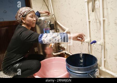 (171222) -- WUZHONG, 22 dicembre 2017 -- Villager ma Xiaolan raccoglie acqua di rubinetto a casa presso Hantianling Village of Hexi Township, Wuzhong City, Ningxia Hui Autonomous Region, 21 dicembre 2017. Wells era una fonte di acqua potabile per gli abitanti di Hantianling, che furono trasferiti in altri luoghi più vivibili nel 2013. Hantianling, che significa montagna della siccità in cinese, si trova nella regione montuosa più remota di Ningxia. L'evaporazione annuale qui è superiore a 2.000 mm, mentre le precipitazioni annuali sono solo di circa 200 mm. La siccità è sempre stata la più grande minaccia per la popolazione locale. Lì Foto Stock