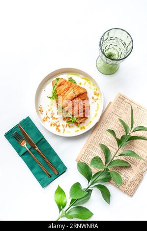 Croissant con formaggio e verdure in piatto bianco. Vista dall'alto sul tavolo bianco Foto Stock