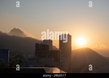 Rio de Janeiro, Brasile: Skyline della città con il Pan di zucchero e la funivia avvolta nella nebbia dopo l'alba, alla luce del sole di prima mattina Foto Stock