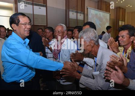 (180113) -- PHNOM PENH, 13 gennaio 2018 -- il primo ministro cambogiano Samdech Techo Hun Sen (1st L) viene accolto dai ciclisti a Phnom Penh, Cambogia, il 13 gennaio 2018. Hun Sen sabato ha ospitato un pranzo per la prima volta per 308 operatori di ciclo e ha lanciato una Cyclo Foundation. Cyclo è un risciò trainato da biciclette a tre ruote che il conducente poggia in alto sopra la ruota posteriore e i passeggeri in un sedile a secchiello incastrato tra le due ruote anteriori. ) (Zjl) CAMBOGIA-PHNOM PENH-PM-CYCLO Sovannara PUBLICATIONxNOTxINxCHN Foto Stock