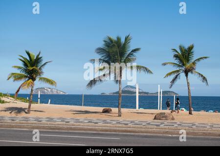 Rio de Janeiro, Brasile: La spiaggia di Ipanema, una delle spiagge più famose al mondo, con l'iconico marciapiede grafico lungo l'Avenida Atlantica Foto Stock