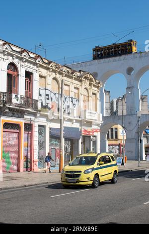 Rio de Janeiro, Brasile: L'Acquedotto Carioca (Arcos da Lapa) con la famosa funivia bonde, tram elettrico sulla strada tra il Centro e Santa Teresa Foto Stock