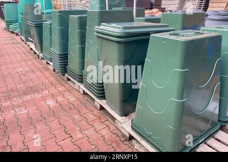 Sistema di raccolta dell'acqua piovana: Una canna e una canalina per tetti. Set di nuovi contenitori grandi verdi per il disimballaggio nel negozio di hardware Foto Stock