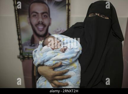 (180211) -- GAZA, 11 febbraio 2018 -- Una donna palestinese tiene il suo neonato in un ospedale a Gaza City, l'11 febbraio 2018. Il bambino di prova, chiamato Mujahid, è nato con lo sperma di contrabbando di suo padre condannato per sette anni nella prigione israeliana. Molte donne palestinesi con mariti che prestano servizio a lungo termine nelle carceri israeliane hanno fatto ricorso a furtivare spermatozoi e rimanere incinte. ) MIDEAST-GAZA-CONTRABBANDO DI SPERMATOZOI WissamxNassar PUBLICATIONxNOTxINxCHN Foto Stock