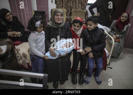 (180211) -- GAZA, 11 febbraio 2018 -- i membri di una famiglia palestinese tendono un neonato all'interno di un ospedale nella città di Gaza, l'11 febbraio 2018. Il bambino di prova, chiamato Mujahid, è nato con lo sperma di contrabbando di suo padre condannato per sette anni nella prigione israeliana. Molte donne palestinesi con mariti che prestano servizio a lungo termine nelle carceri israeliane hanno fatto ricorso a furtivare spermatozoi e rimanere incinte. ) MIDEAST-GAZA-CONTRABBANDO DI SPERMATOZOI WissamxNassar PUBLICATIONxNOTxINxCHN Foto Stock