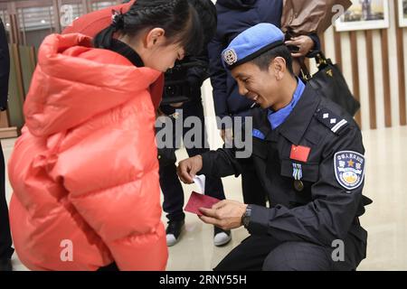 (180228) -- HANGZHOU, 28 febbraio 2018 -- il peacekeeper cinese Wei Yiyi (R) riceve un biglietto di auguri da sua figlia Wei Zixuan all'aeroporto internazionale di Hangzhou Xiaoshan a Hangzhou, capitale della provincia dello Zhejiang della Cina orientale, 27 febbraio 2018, dopo aver condotto una missione di un anno nel Sudan del Sud. La sesta squadra di polizia cinese di mantenimento della pace in Sud Sudan, con sette membri tutti selezionati da Zhejiang, è arrivata a Hangzhou martedì sera. Nel Sud Sudan, gli agenti di polizia svolsero una serie di compiti nella capitale Juba e Wau, tra cui pattuglie di campi profughi, aiuti umanitari e comuni Foto Stock