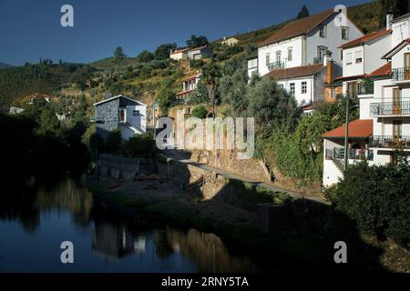 Un fiume e un villaggio ai piedi della Serra da Estrela, Portogallo. Foto Stock