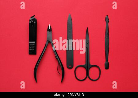 Set di strumenti per pedicure su sfondo rosso, spianatura piatta Foto Stock