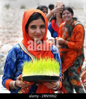 (180325) -- JAMMU, 25 marzo 2018 -- Un devoto indù porta un Saakh o alberelli d'orzo raffiguranti la dea Durga prima di immergerlo nel fiume Tawi l'ultimo giorno di Navratri, un festival indù a Jammu, la capitale invernale del Kashmir controllato dall'India il 25 marzo 2018. ) (Zxj) INDIA-JAMMU-NAVRATRI FESTIVAL Stringer PUBLICATIONxNOTxINxCHN Foto Stock