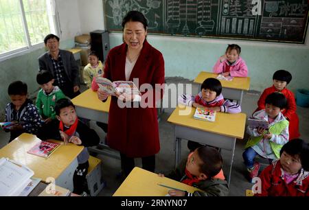 (180327) -- PINGLI, 27 marzo 2018 -- li Zhaoqiong, moglie di Ye Shiping, racconta una favola in classe a scuola nella città di Xihe della contea di Pingli, provincia dello Shaanxi della Cina nord-occidentale, 26 marzo 2018. YE Shiping, 53 anni, decise di rimanere alla Renjiaya Primary School come insegnante con sua moglie, dato che il numero di studenti qui scese a soli 15. La scuola, situata in una remota area montuosa, dista 30 chilometri dalla contea. Con la riduzione della popolazione, Ye e sua moglie divennero gli unici due insegnanti rimasti nella scuola. Prendendosi cura dei loro studenti, la coppia ha deciso di dev Foto Stock