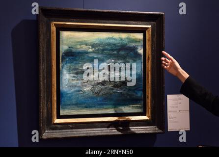 (180327) -- HONG KONG, 27 marzo 2018 -- Un membro dello staff introduce Composition en bleu , un'opera del pittore cinese-francese Zao Wou-Ki, durante le aste primaverili di Poly Auction di Hong Kong del 2018 a Hong Kong, 27 marzo 2018. ) (lmm) CINA-HONG KONG-POLI-ASTE (CN) QinxQing PUBLICATIONxNOTxINxCHN Foto Stock