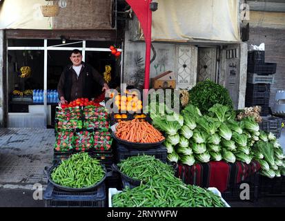 (180406) -- GHOUTA ORIENTALE, 6 aprile 2018 -- Un fruttivendolo organizza verdure nella sua bancarella nella città recentemente riconquistata di Ayn Tarma nella campagna orientale di Ghouta a Damasco, in Siria, il 5 aprile 2018. L'ultima area detenuta dai ribelli nella capitale Damasco, la campagna di Ghouta orientale sta per cadere, con un nuovo accordo che vedrà l'evacuazione dei ribelli dell'esercito islamico verso la Siria settentrionale. (psw) SYRIA-DAMASCO-EASTERN GHOUTA-DAILY LIFE AmmarxSafarjalani PUBLICATIONxNOTxINxCHN Foto Stock