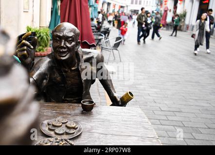 (180425) - HAIKOU, 25 aprile 2018 -- i turisti camminano sull'antica via Qilou ad Haikou, capitale della provincia di Hainan della Cina meridionale, 12 febbraio 2018. Gli edifici Qilou in stile Nanyang sono edifici affittuari di tipo balcone per uso sia residenziale che commerciale. Il primo piano di una casa Qilou è usato come negozio, e parte del secondo piano è appeso al primo piano ed è sostenuto da colonne, formando un riparo di fronte al negozio. La gente vive ai piani superiori. Le case di Qilou si allineano per formare una strada dello shopping, lasciando strapiombi su entrambi i lati della strada per proteggere i pedoni. Yang Guanyu)(wsw)(z Foto Stock