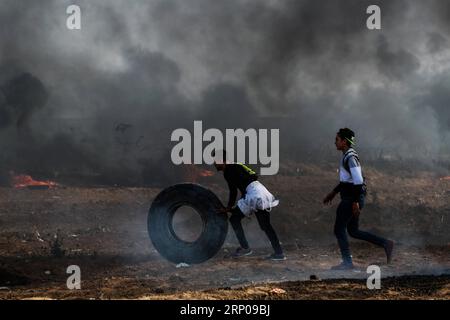 (180427) -- GAZA, 27 aprile 2018 -- i manifestanti palestinesi spostano una gomma per bruciarla durante gli scontri con le truppe israeliane durante gli scontri a est della città di Gaza, il 27 aprile 2018. Stringer) MIDEAST-GAZA-CLASHES zhaoyue PUBLICATIONxNOTxINxCHN Foto Stock