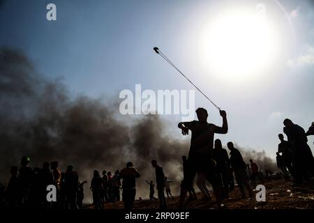 (180427) -- GAZA, 27 aprile 2018 -- Un manifestante palestinese usa una fionda per lanciare pietre contro le truppe israeliane durante gli scontri ad est della città di Gaza, il 27 aprile 2018.Stringer) MIDEAST-GAZA-CLASHES zhaoyue PUBLICATIONxNOTxINxCHN Foto Stock