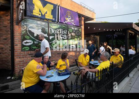 Ann Arbor, Michigan, USA. 2 settembre 2023. I tifosi della University of Michigan in magliette di mais festeggiano al The Beer Grotto in Ashley Street nel centro di Ann Arbor dopo che Michigan ha sconfitto la East Carolina 30 a 3 nella prima gara della stagione alla Big House di Ann Arbor. (Immagine di credito: © Mark Bialek/ZUMA Press Wire) SOLO USO EDITORIALE! Non per USO commerciale! Foto Stock