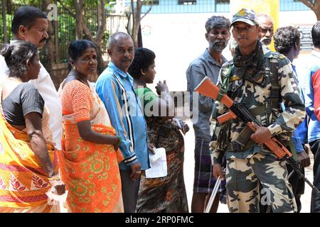 (180512) -- BANGALORE, 12 maggio 2018 -- Un membro della sicurezza è in guardia accanto agli elettori che si schierano per esprimere i loro voti in un collegio elettorale durante le elezioni dell'assemblea del Karnataka a Bangalore, in India, il 12 maggio 2018. Lo stato meridionale indiano del Karnataka è andato alle urne sabato, visto come un preludio alle elezioni generali che si terranno l'anno prossimo. (srb) INDIA-BANGALORE-KARNATAKA ASSEMBLEA ELEZIONE Stringer PUBLICATIONxNOTxINxCHN Foto Stock