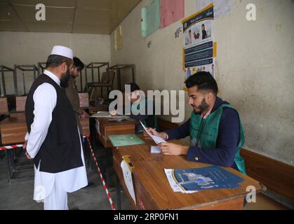 (180512) -- KABUL, 12 maggio 2018 -- un lavoratore della commissione elettorale afghana controlla l'identità di un uomo in un centro di registrazione elettorale a Kabul, capitale dell'Afghanistan, 12 maggio 2018. La Commissione elettorale afghana (CEI) ha esteso la registrazione degli elettori per le elezioni parlamentari e dei consigli distrettuali, da tempo ritardate, previste per il 20 ottobre, per consentire agli elettori più idonei di registrarsi, ha detto la CEI venerdì. Rahmat Alizadah) (srb) AFGHANISTAN-KABUL-VOTER REGISTRATION-EXTENSION XinhuaxKabul PUBLICATIONxNOTxINxCHN Foto Stock