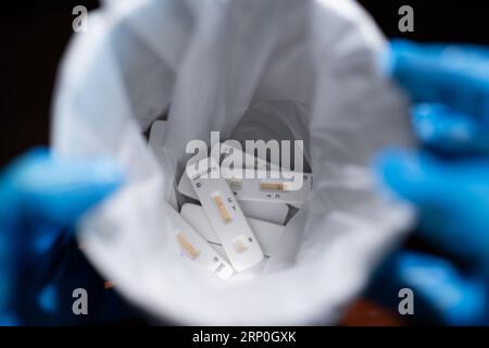 Personale medico smaltimento dei kit di test dell'antigene Covid-19 usati Foto Stock